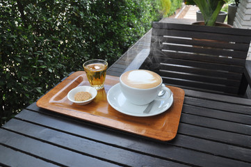 white cup of hot coffee on wooden table in coffee shop,white cup of hot coffee on wooden table on green natural background