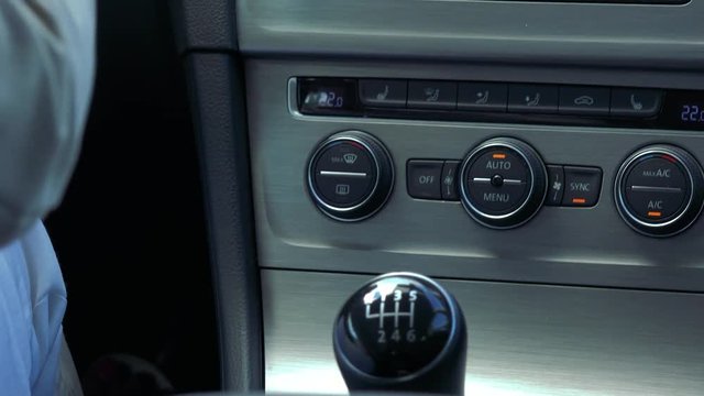 Middle aged woman drives a car and shifting - closeup of manual gearbox 