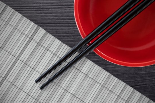 Composite image of close up of black chopstick with bowl