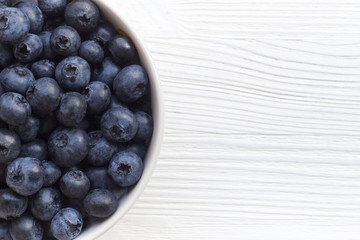 Plate with blueberries on a wooden table