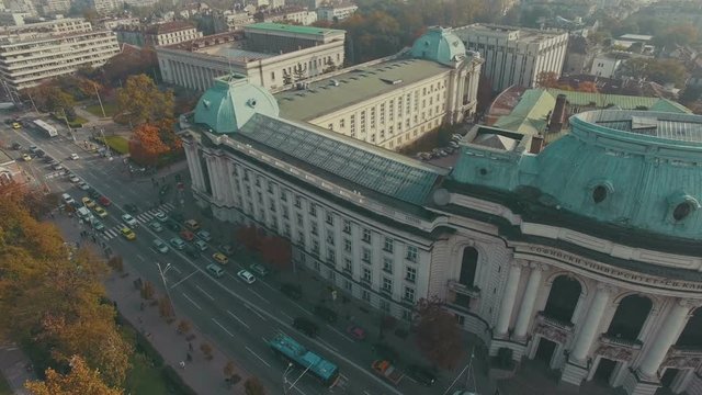 Aerial over busy boulevard with massive university structure