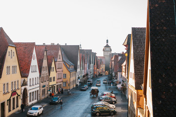 Obraz premium View from a high point to a beautiful street with traditional German houses in Rothenburg ob der Tauber in Germany. Ahead of the city tower. Sightseeing of the city. European city.