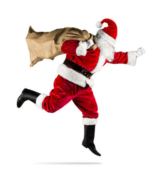 red traditional santa claus with bag of christmas gifts presents running jumping isolated on white background / Weihnachtsmann in eile rennt mit Sack voll Geschenke isoliert auf hintergrund weiß