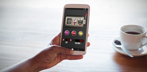 Composite image of slot machine with text on mobile display