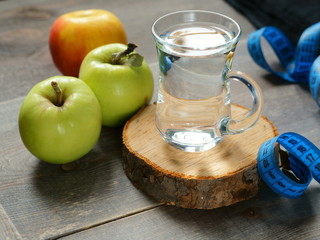 a glass of water and green apples
