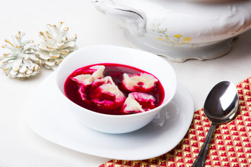 Barszcz czerwony z uszkami na bialym obrusie. Danie Wigilijne