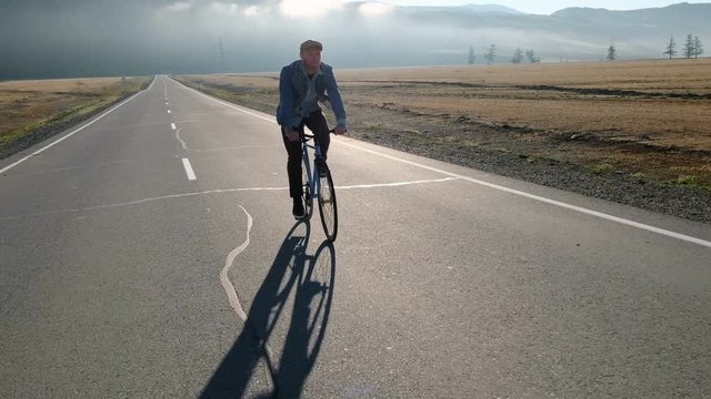 Rear View of a Young Man With Bicycle on Summer Nature Background. Healthy Lifestyle Concept. 20s 4k.