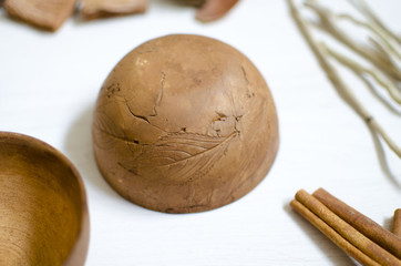 Clay pottery isolated. Decorative dark brown ceramics on the white wooden table