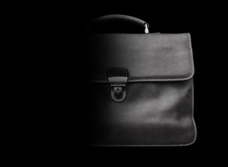 Expensive leather briefcase on a black background.