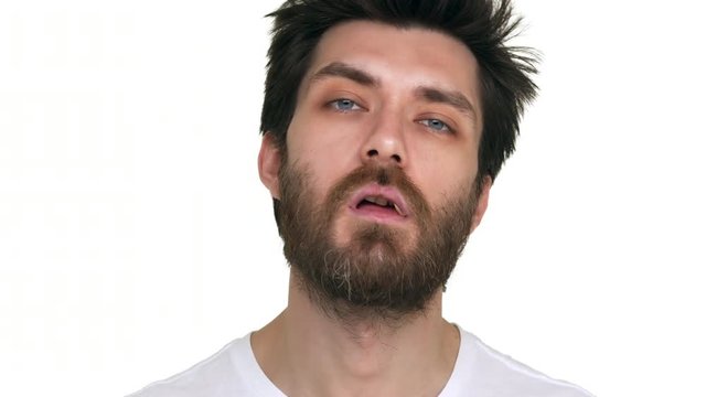 Young bearded man with a toothpick in mouth acting loose on white background