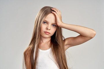 girl with long straight hair holding her head, portrait