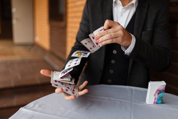 The magician deftly goes through a deck of beautiful playing cards for magic tricks making them arch in the air