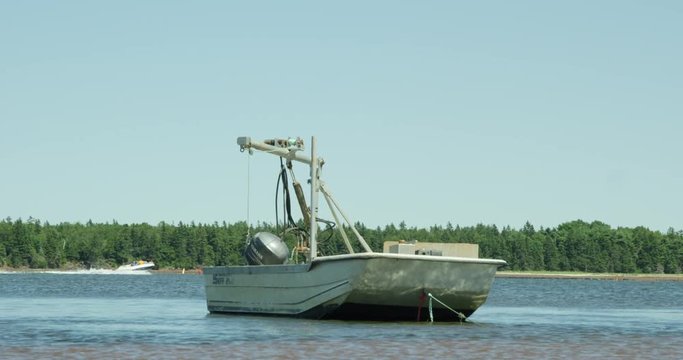 Mussels and oyster boat crane on water - speed boat passing behind