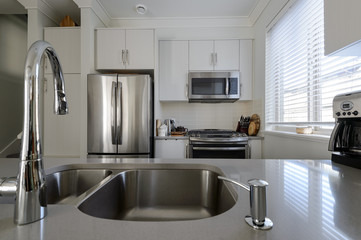 Modern white kitchen with stainless steel appliances. Interior design.
