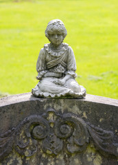kleines Blumenmädchen auf einem Grabstein