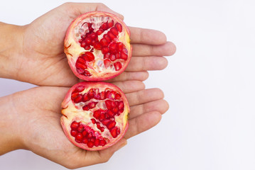 Hand Holding Pomegranate Fruit Cut Into Half Over White Background