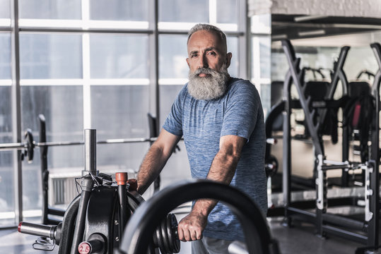 Serious old sportsman is spending time in athletic center