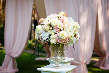 Tall crystal vase with beautiful bouquet of daisies and roses on top