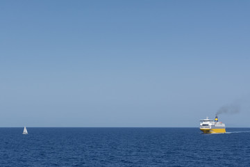 view of an yellow ferry and small yacht at the calm blue sea