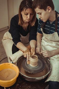 teacher and student work on the potter's wheel