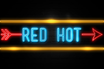 Obraz premium Red Hot - fluorescent Neon Sign on brickwall Front view