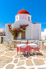 Traditional Greek church building with red dome and whitewashed facade in old town of Mykonos island. Cyclades islands,  Greece.