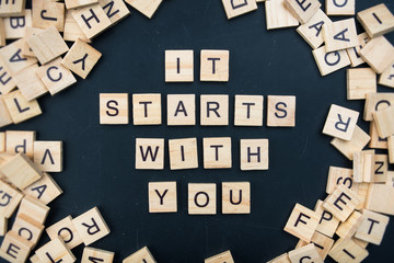 The letters on the black background form the text "it starts with you"