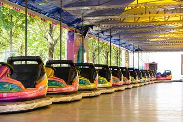 Fototapeta na wymiar Colorful dodgem cars lined up on the side of the track waiting for kids in a funfair.