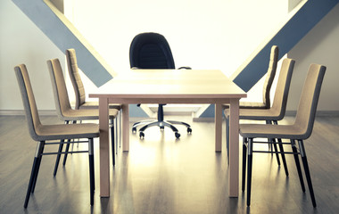 Empty wooden table and chairs in conference room