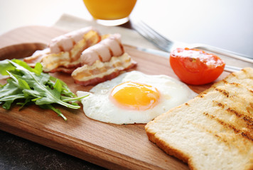 Tasty breakfast with egg on wooden board