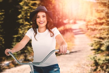 Composite image of portrait of happy woman cycling on bicycle