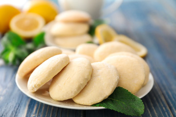 Plate with homemade lemon cookies on wooden table, closeup