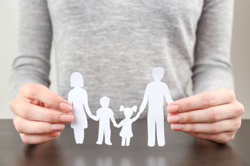 Fototapeta na wymiar Woman holding paper silhouette of family, closeup. Insurance concept