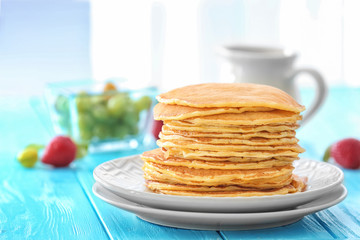Plate with delicious pancakes on table