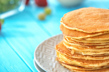 Plate with delicious pancakes on table