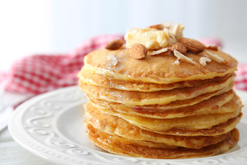 Delicious pancakes with nuts and butter on plate