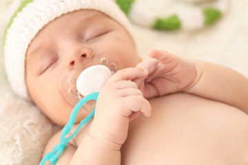 Cute little baby with pacifier sleeping at home, closeup