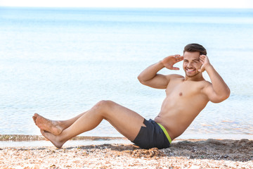 Fototapeta na wymiar Handsome young man training on sea beach