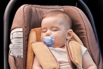 Adorable baby sleeping in child safety seat