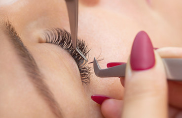 Eyelash removal procedure close up. Beautiful Woman with long lashes in a beauty salon. Eyelash...