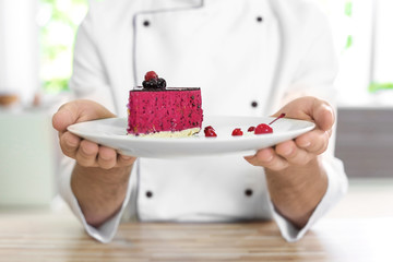 Chef holding delicious berry cheesecake, closeup