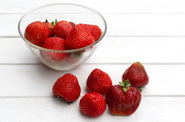 still life with ripe juicy strawberries lay in a dish and close on a white table