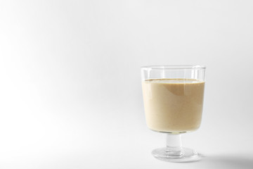 Glass of fresh protein smoothie on white background
