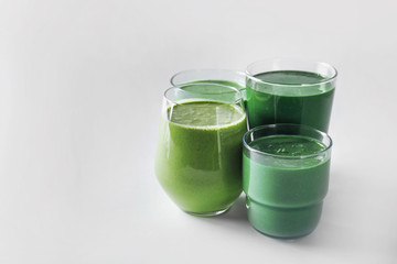 Glasses of fresh green smoothie on white background