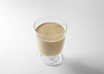 Glass of fresh protein smoothie on white background