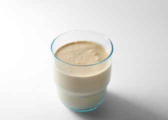 Glass of fresh protein smoothie on white background