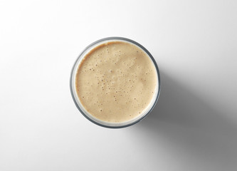 Glass of fresh protein smoothie on white background