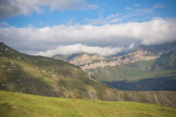 Obraz na płótnie Canvas Горный пейзаж. Красивый вид на живописное ущелье, панорама горной местности, белые облака на синем небе. Природа и горы Северного Кавказа