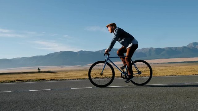Rear View of a Young Man With Bicycle on Summer Nature Background. Healthy Lifestyle Concept. 20s 4k.