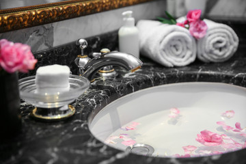 Petals floating in marble sink. Spa concept